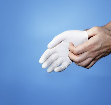 A Doctor putting on or removing a white latex rubber protective glove.