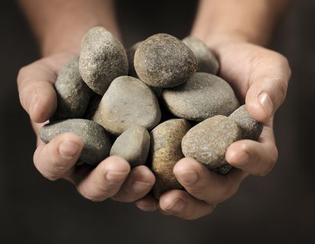 Man holding different small rocks in his hands