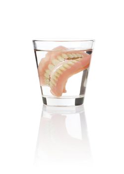 Old dentures in a glass of water