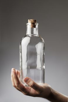 Man holding an old-fashioned glass bottle in his hand.