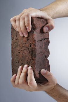 Hands holding an old brick
