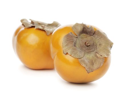 Two persimmon sharon fruits isolated on white with natural shadows