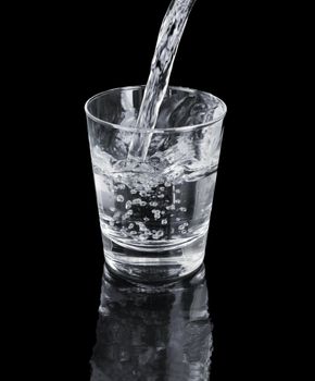 A Glass of clean water on black reflecting backdrop