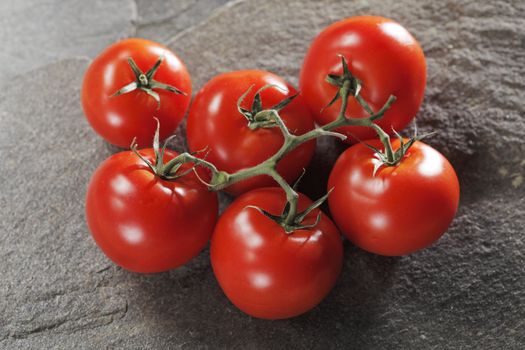 Red ripe tomatoes on stone background