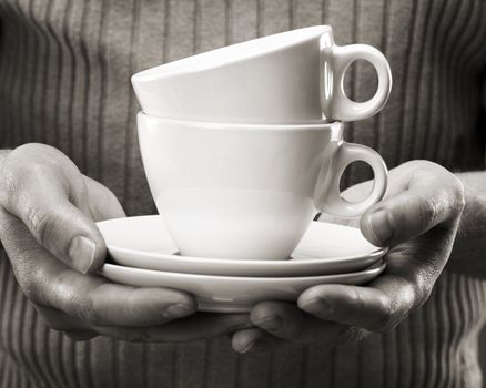 Man holding coffee cups in his hands.