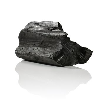 A Lump of charcoal made of wood on reflective background