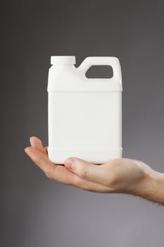  Hand holding a small white blank container