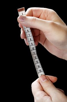 Hands holding a metric white tape measure