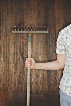 Man holding an old rake