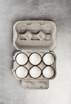 Six chicken eggs in a carton