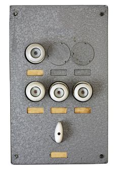 Old metallic wall-mounted fusebox with blank labels.