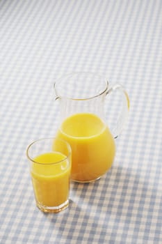 Orange juice in a glass and a pitcher