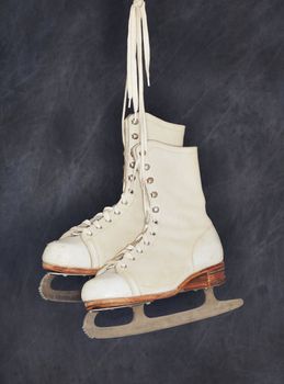 Old womens figure skates hanging from their laces