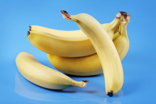 Still life with yellow bananas on blue.