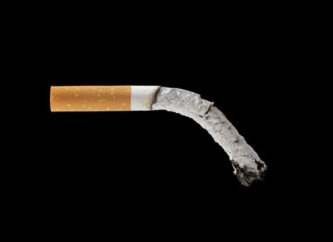 A burned out filter cigarette on black background