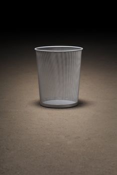 Empty wastepaper basket on dirty concrete floor