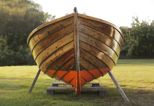 Old wooden boat winter storaged on lawn.