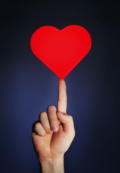 Man holding a glowing red heart on his fingertip