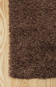 New brown hairy rug on hardwood floor