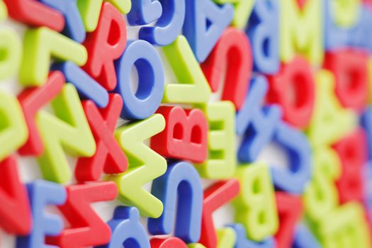 Plastic fridge magnets on white background. Short depth of field.