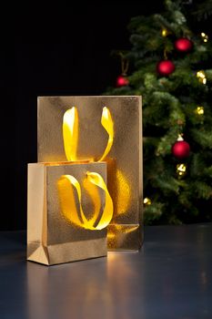 Two golden shopping bags in an elegant Christmas setting