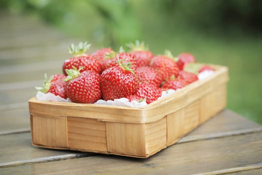 Fresh strawberries in a small wooden basket