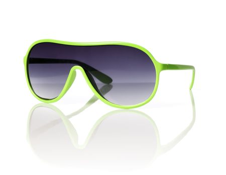 Cheap green plastic 1980s style sunglasses on reflective background.