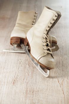 Old white women's ice skates on wood