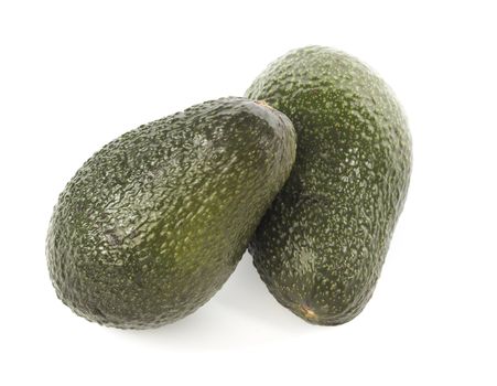 Two avocado fruits on white with natural shadows.