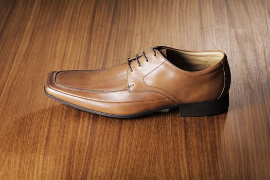 Men's leather shoe on wood