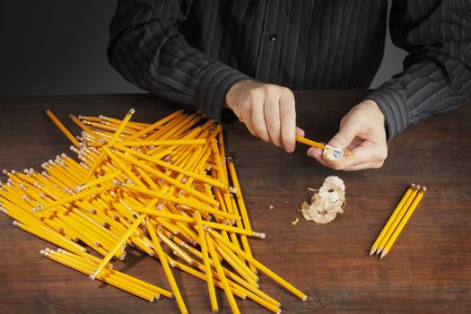 Man sharpening pencils with a pencil sharpener