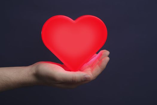 Man holding a red glowing heart on his palm.