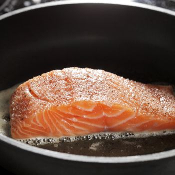 A Salmon fillet on a frying pan