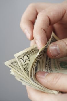 Counting old dollar bills with fingers. Short depth of field.