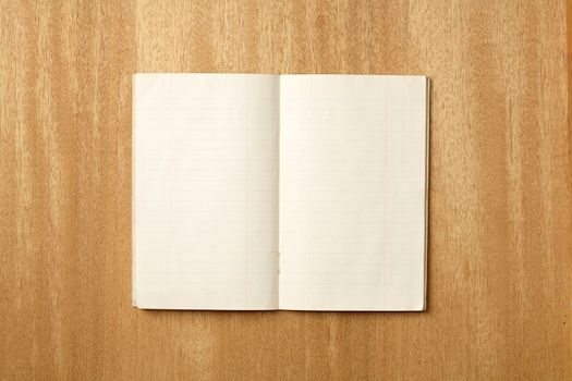 Old small notebook open on a wooden surface
