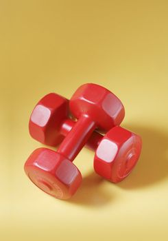 Red light plastic dumbells on yellow surface