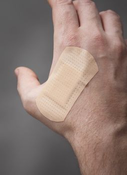 Hand with plastic adhesive bandage