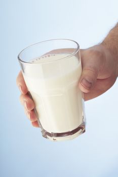 A Hand holding a glass of milk