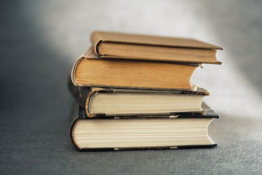 Stack of old books on grey background. Very short depth of field.