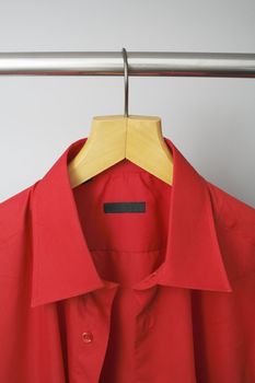 A Red men's dress shirt hanging on a hanger