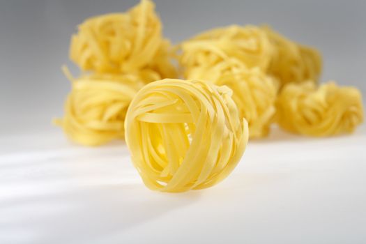 Uncooked italian pasta tagliatelle photographed using a spotlight