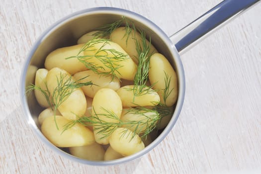 New potatoes with dill in steel pot