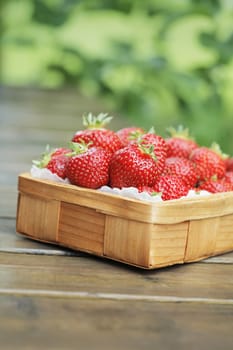 Fresh strawberries in a small wooden basket