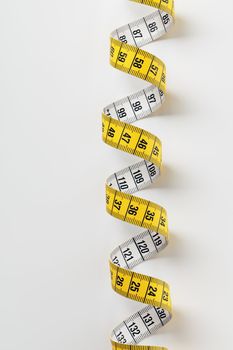 Yellow tape measure on light grey background