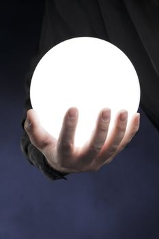 Man holding a glowing white sphere in his hand.