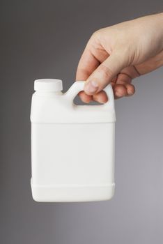 A Small white blank plastic container in a hand