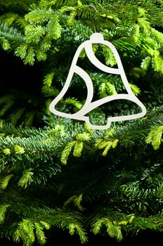 Bell shape Christmas ornament in fresh green Christmas tree
