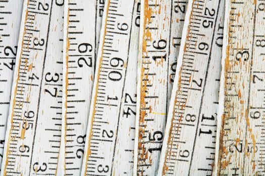 Old and worn white folding carpenters ruler in closeup