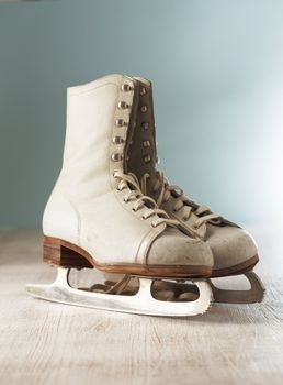 Old white women's ice skates on wood