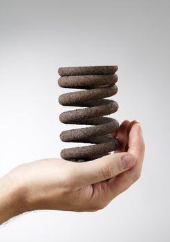 Man holding an old rusty spring in his hand.